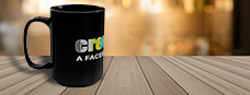 black coffee mug with the Crew Call logo sitting on a wooden table